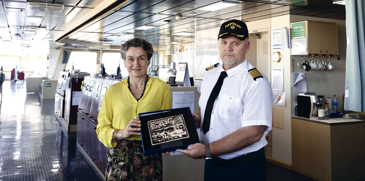 Mar Chao, presidenta de la Autoridad Portuaria de Valencia, haciendo entrega del tradicional socarrat con la imagen del puerto de Valencia al capitán del buque, Andriy Ney.