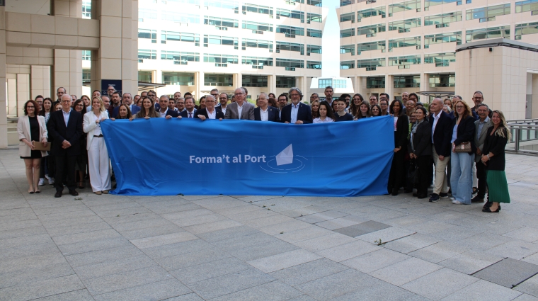 Todos los asistentes en la celebración del 10º aniversario de Forma’t al Port posaron detrás de una pancarta del programa.