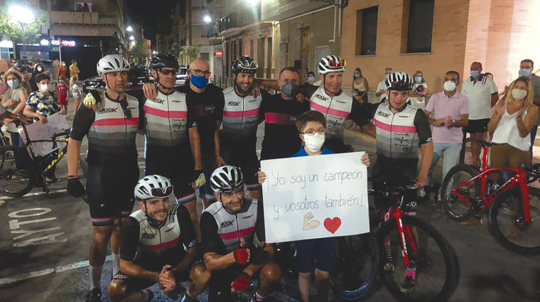 Roberto Peris, en el centro de la imagen con la pancarta, junto a los miembros del equipo ciclista que participaron en la acci&oacute;n solidaria.
