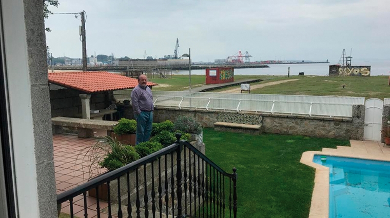 Julio Carrasco, en el jard&iacute;n de su casa con el puerto de Vilagarc&iacute;a en el horizonte.