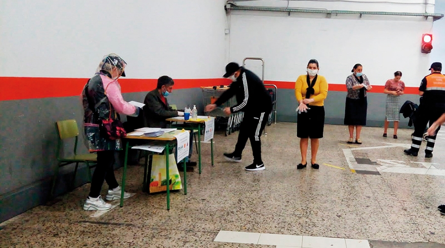 Momento de una de las entregas de los vales de comida, con la colaboraci&oacute;n de Protecci&oacute;n Civil.
