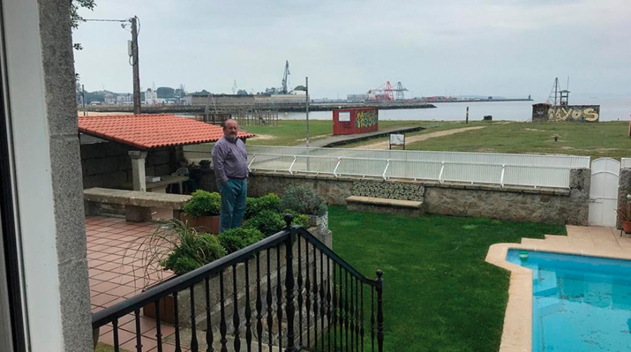 Julio Carrasco, en el jard&iacute;n de su casa con el puerto de Vilagarc&iacute;a en el horizonte.