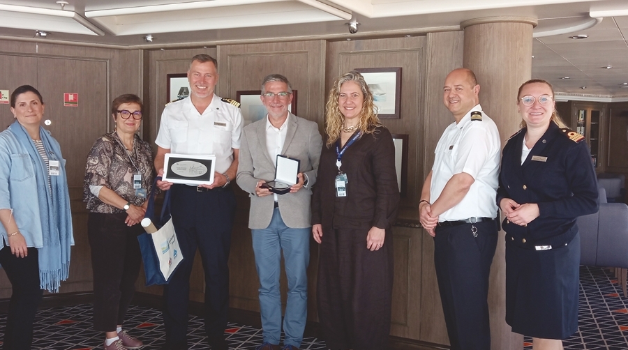 El presidente de la APS, César Díaz (4º por la izquierda), entrega una metopa al capitán del barco, junto a parte de la tripulación y representantes de Santander Cruise Deluxe.